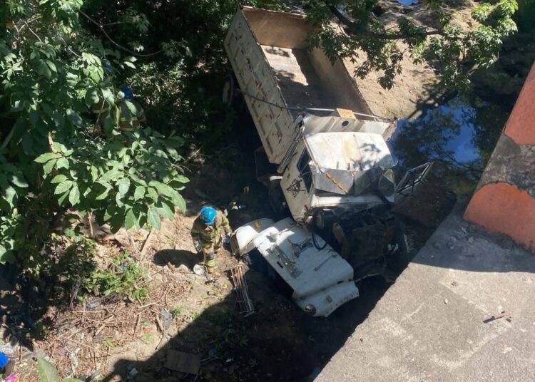 Camión de carga cae a un barranco desde un puente